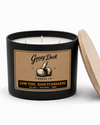 Gooey Duck candle with a wooden lid on a white background
