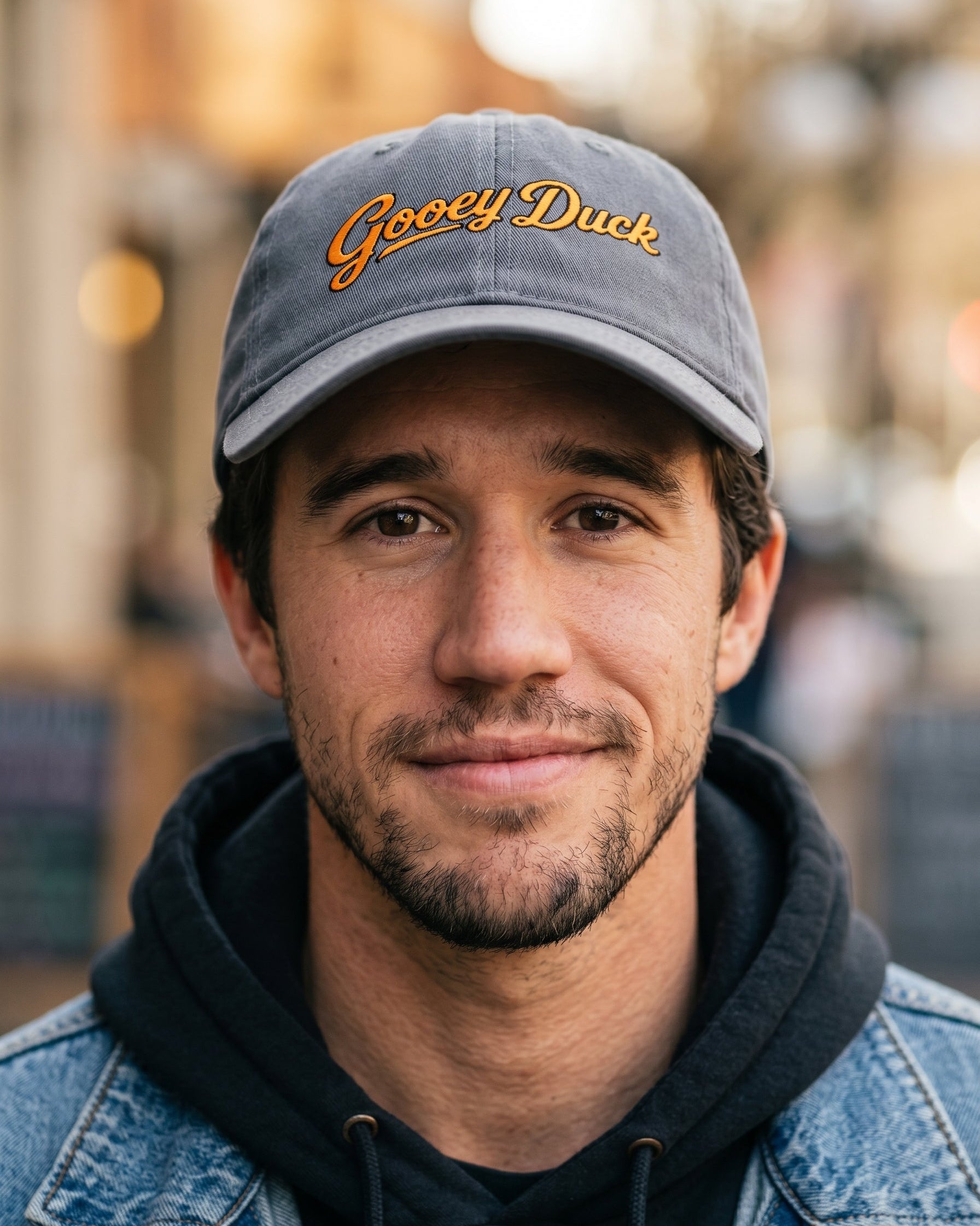 Model wearing charcoal Gooey Duck Logo Cap